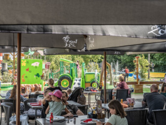 Het terras van Speelboerderij Pierewiet kijkt uit op de waterspeeltuin